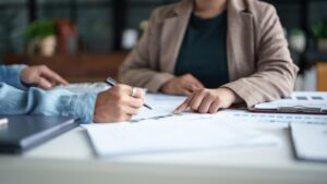 Profissionais analisando documentos e planilhas, representando adaptações ao Portal Único de Importação e mudanças no processo aduaneiro.