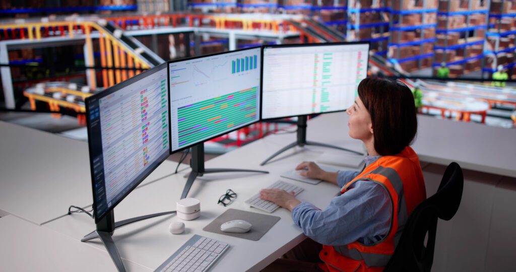 Profissional monitorando indicadores e sistemas logísticos em operação automatizada.