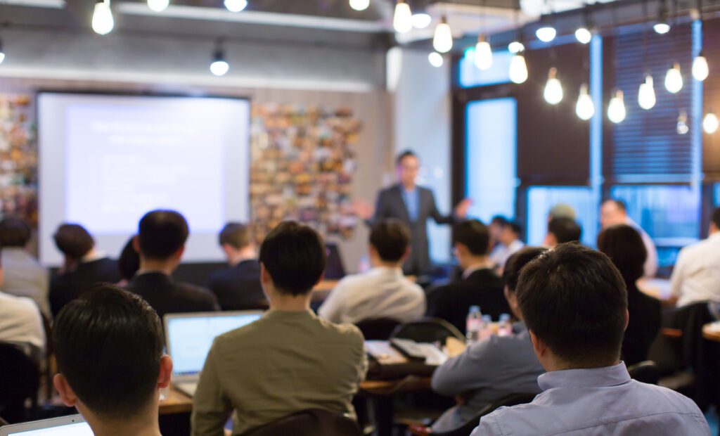 Equipe acompanhando apresentação de treinamento corporativo voltado para operações empresariais.