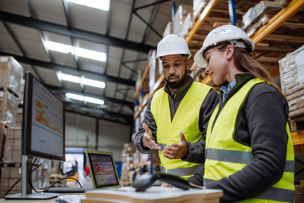 Equipe logística analisando processos operacionais durante treinamento em centro de distribuição.